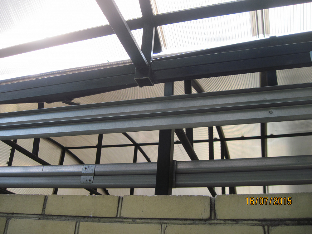 Ворота секционные Алютех под металлическим навесом. Въезд во двор S-гофр RAL 8014.